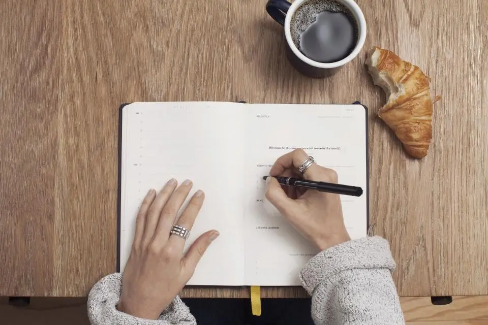Manos escribiendo en un cuaderno